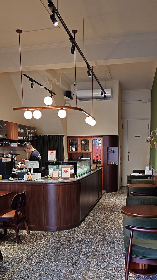 蛙鳴甜點入門景色，木質的弧形櫃台，吊著球狀的燈