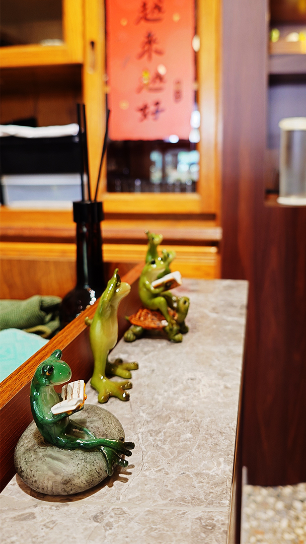 蛙鳴甜點青蛙裝飾，背後有越來越好的春聯