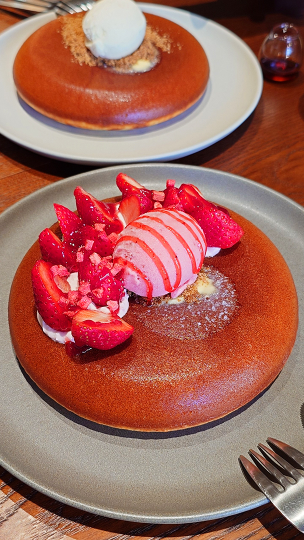 蛙鳴草莓鬆餅近照，上面有一球草莓冰淇淋淋上草莓醬，以及許多新鮮草莓